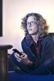 Man gazes at a TV screen