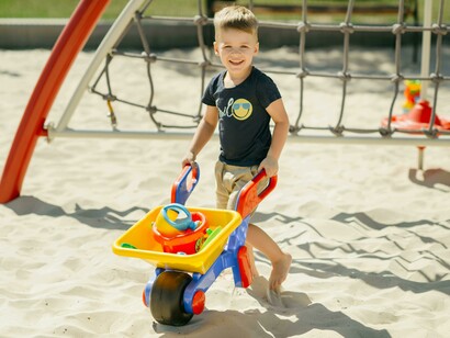A group of children playing together in a sandy playground