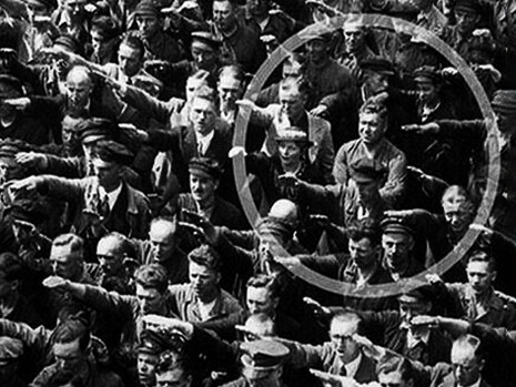 Un hombre que se niega a hacer el saludo nazi en medio de una multitud