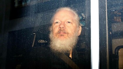 Assange a bordo del furgone della polizia durante l'arresto
