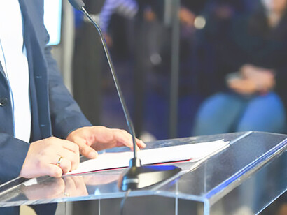 A politician addresses the public with a compelling speech from the lectern