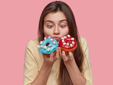 A woman clutching a doughnut, her eyes reflecting a deep craving and the grip of sugar addiction