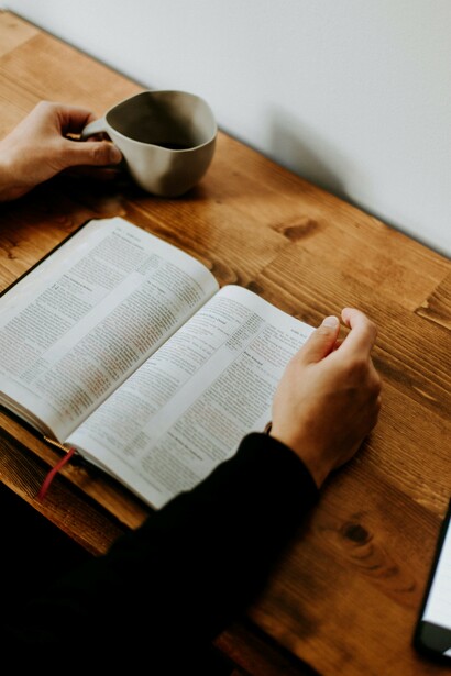 A man reading the Bible in church, seeking guidance and strength through scripture during his spiritual struggle and path to renewal