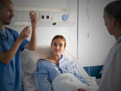 Doctor and nurse assisting patient with IV therapy administration in a clinical setting