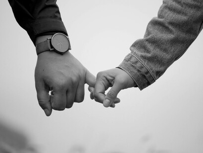 Woman holds pinky of man