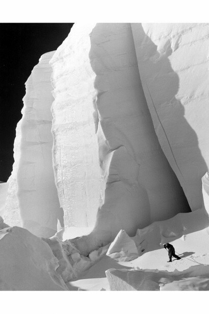 Norman Bright is dwarfed beneath a huge ice-wall just east of Silverthrone Col, 12 miles east of Mt Mckinley, 1945, © Bradford Washburn, courtesy Decaneas Archive and Michael Hoppen Gallery
