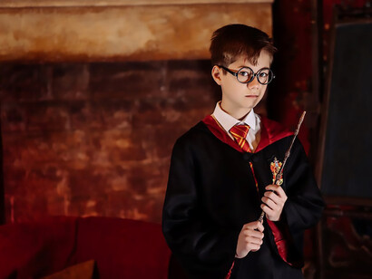 A spirited boy, adorned in a meticulously crafted Harry Potter costume, proudly wields a wand, stepping into the magical world with unwavering enthusiasm
