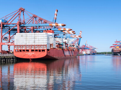 A busy container port filled with cargo ships and shipping equipment, reflecting the strategic importance of international supply chains