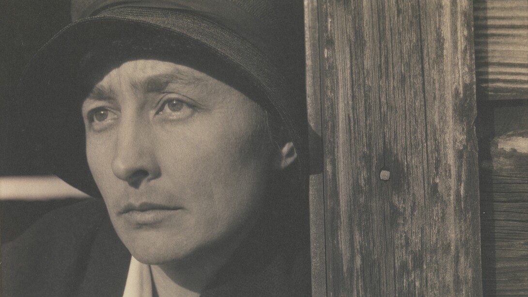 Georgia O'Keeffe con cappello nero, contro lo stipite di una porta di legno - fotografia di Alfred Stieglitz, Metropolitan Museum of Art, New York, Usa