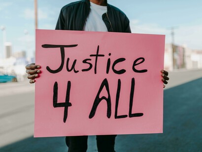 A person holding a pink sign asking for equal justice