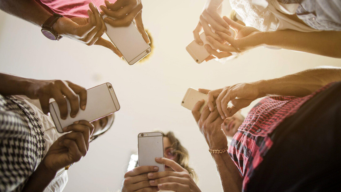 Grupo de personas mira su teléfono móvil sin convivir entre sí