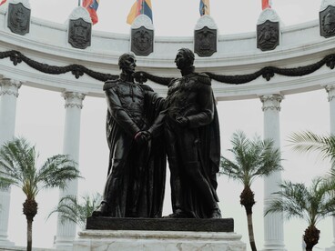 Escultura homenageia Simón Bolívar e José de San Martín, líderes que simbolizam a luta pela autonomia das nações sul-americanas frente ao domínio colonial espanhol. O texto analisa os desafios contemporâneos da soberania política na América Latina