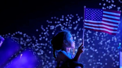 A little girl holding the American flag, celebrating Independence Day on July 4th