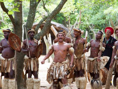 Dressed in traditional warrior attire, Zulu men display their cultural pride and strength as they perform a captivating dance, echoing the rhythms of their ancestors