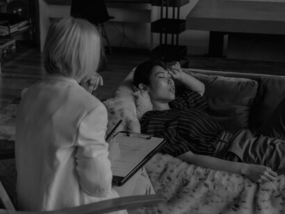 A woman lies on the couch in her therapist's office, questioning her life and past