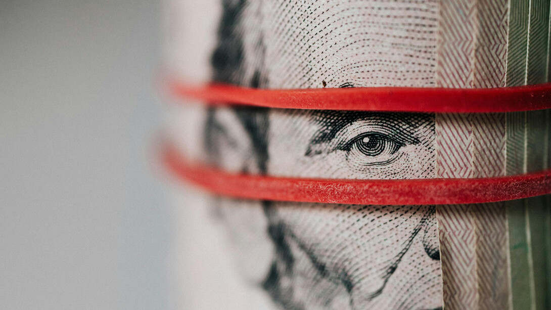 Close up of a US dollar bill featuring Abraham Lincoln tied with a rubber band