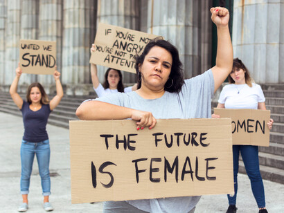 Young women advocating together with handwritten placards, illustrating the power of youth-driven movements