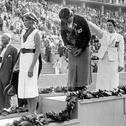 La danese Inge Sorensen, medaglia di bronzo, la giapponese Hideko Maehata, medaglia d'oro, e la tedesca Martha Genehger posano sul podio durante la cerimonia di premiazione della gara di nuoto femminile dei 200 metri rana alle Olimpiadi di Berlino, tenutasi allo Stadion der Schwimmer l'11 agosto 1936 a Berlino, in Germania.