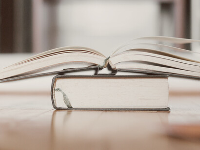Un libro abierto encima de otro tomo cerrado, esperando a que se extinga su predecesor