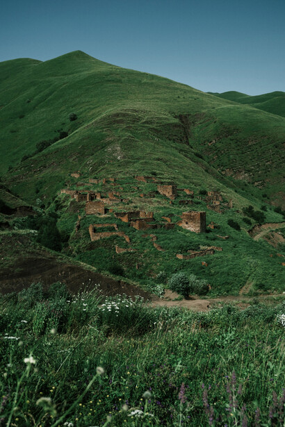 The remains of historic dwellings across the green slopes in Chechnya, Russia, symbolising a past that remains visible while a new generation looks toward building a stronger future