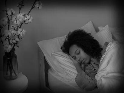 Set up a sleep routine, with no blue lights or interruptions at least an hour before bedtime; a woman getting a good night's rest