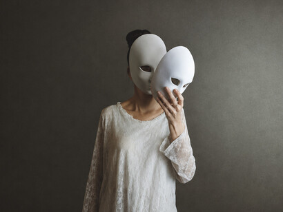 A woman removes a mask from her face, only to uncover another, illustrating the complex layers of identity and the difficulty of exposing one's authentic self