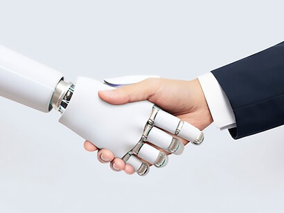 In the backdrop of digital transformation, witness a symbolic handshake between a robot and a human, capturing the essence of artificial intelligence evolution