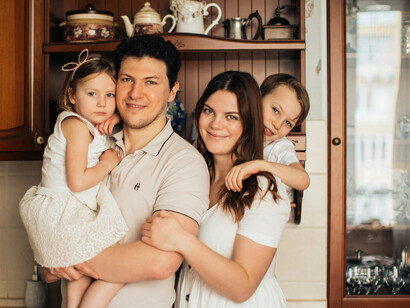 A cheerful family gathered together in a cozy kitchen filled with warm light