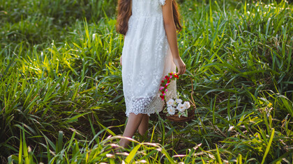 Menina passeia pelo campo para colher flores
