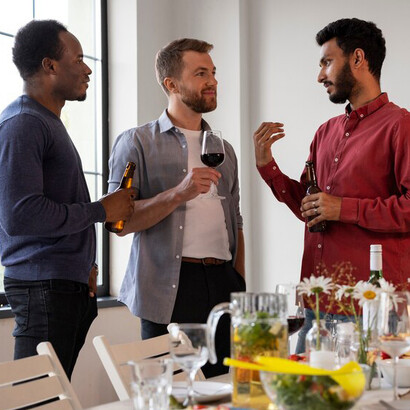 A group of friends share laughter and wine at a cozy dinner party in India