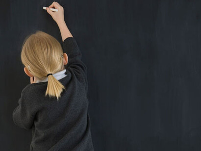 Una niña escribe en la pizarra