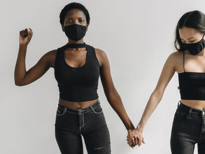 In a powerful display of unity, two Black and Asian women clasp hands to confront racism and marginalization