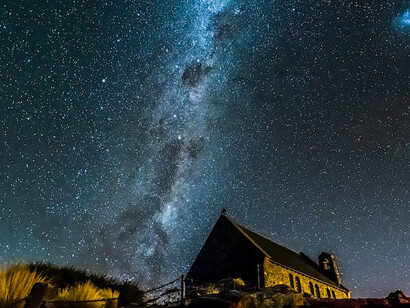 A house under the night sky, surrounded by the Solar System
