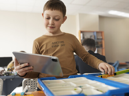 Un bambino sta consultando un tablet in aula