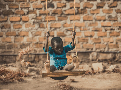 Niño mozambiqueño jugando en un columpio a las afueras de Maputo
