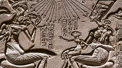 Akhenaten and Nefertiti seated, holding three of their daughters, under the rays of the sun god Aton