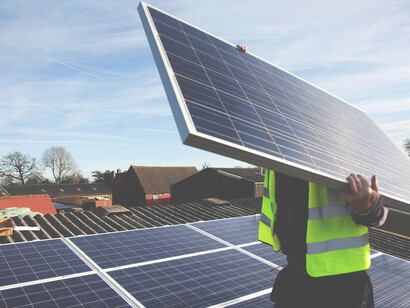 A worker installing solar panels. Who defines “green” and “sustainable?” 