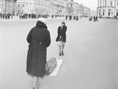 Uma mulher e uma adolescente arrastam um corpo envolto em um cobertor pela Avenida Nevsky. URSS, Leningrado