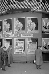 Political posters in Paris, such as the "Jojo la Colombe" caricature of Stalin, represent the intense battle against communism during a turbulent period in history