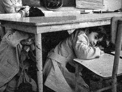 Niños ensayan el protocolo de seguridad por bombardeo en una escuela