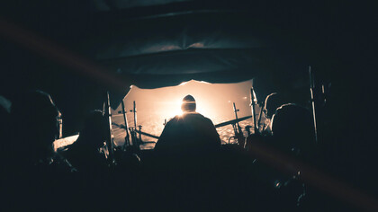 A warzone in Ukraine, featuring a military track with soldiers inside, shrouded in dramatic smoky light and sparkles of glare from the transport, reflecting the intensity of the battlefield