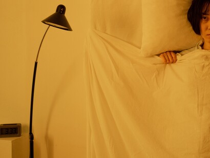 A woman laying on her bed, with eyes wide open, suffering from insomnia