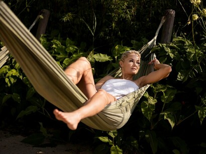 A woman relaxing at an outdoor spa in a sustainable boutique hotel, showcasing eco-friendly hospitality and green architecture