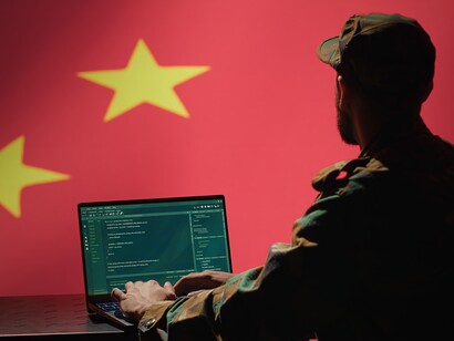Militare al computer con bandiera cinese sullo sfondo