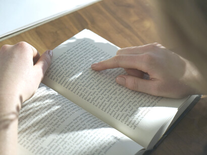 Mujer lee un libro acompañada por la luz de la mañana
