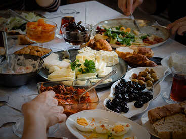 A family gathers around the table to enjoy a traditional Turkish breakfast with a variety of local specialties