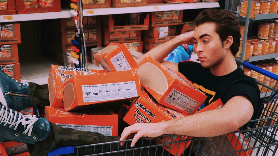 Depressed-looking man slumped on a shopping cart, symbolizing the emotional toll of unhealthy lifestyle habits