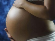 A pregnant black woman taking ownership of her womb