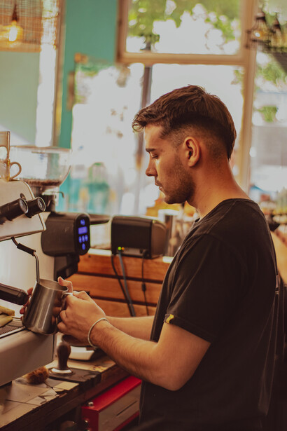 Barista sirviendo leche. Para realizar arte latte se necesita mucha práctica y diversos elementos e ingredientes