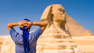 A man standing in front of the Great Sphinx of Giza, Egypt